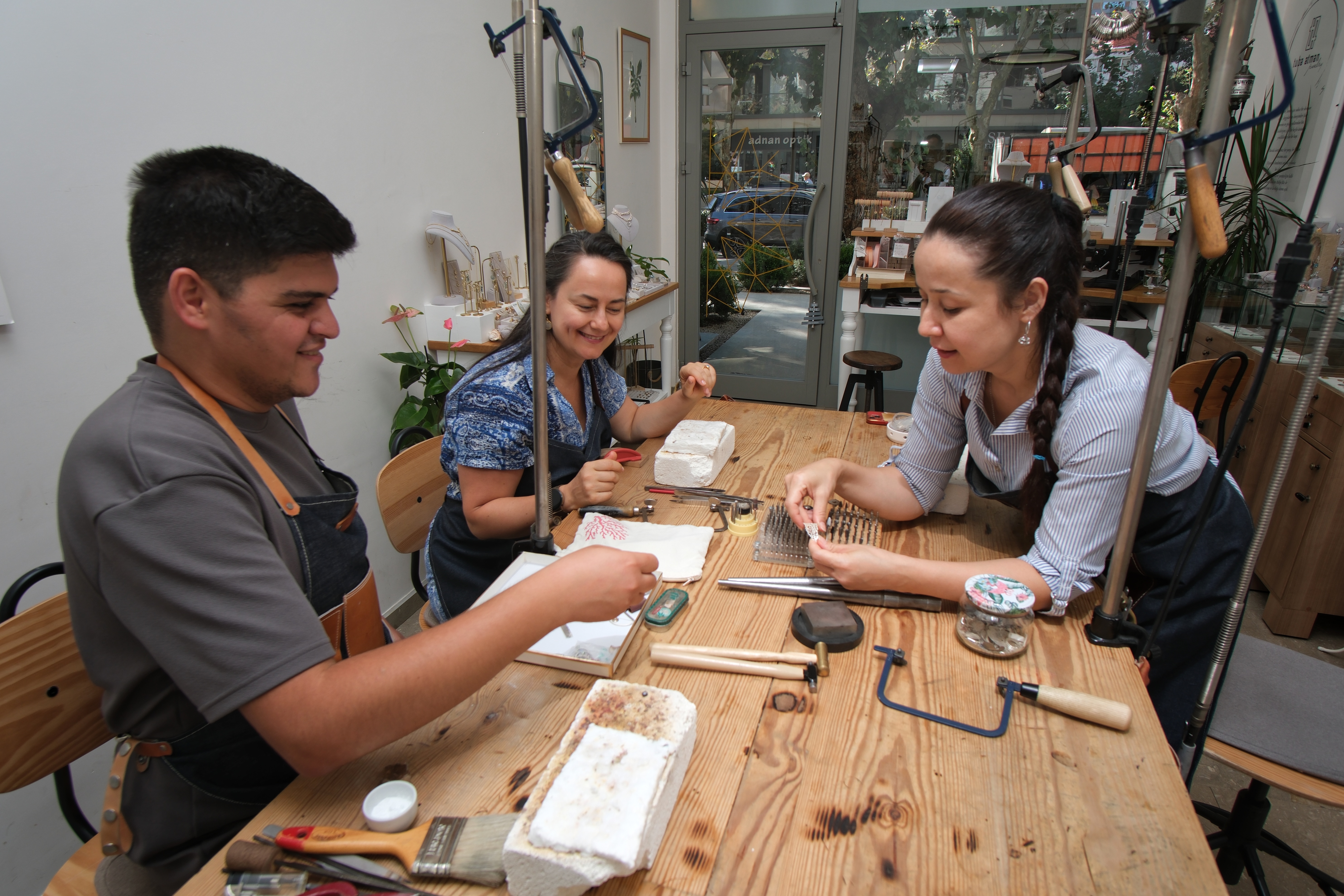 Three participants working at the jewellery bench in the studio