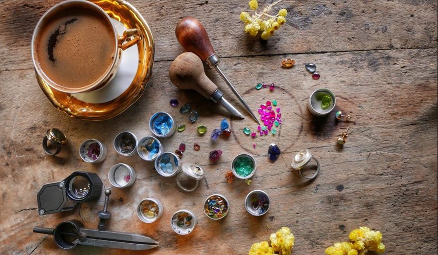 A cup of coffee, stones and tools on the workshop bench